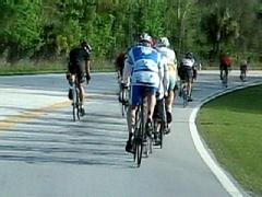 a group of cyclists all riding as individuals on the same section of the highway.